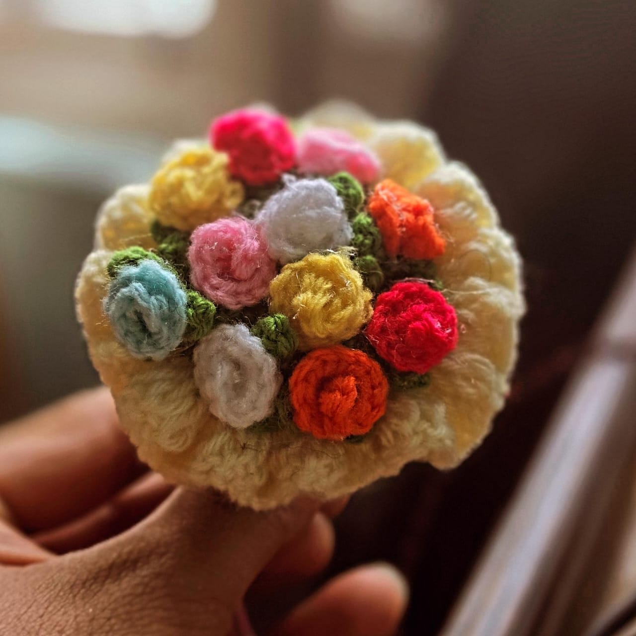 A posy of crochet roses held in two hands