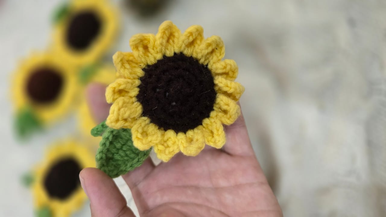 A crochet sunflower held in a hand