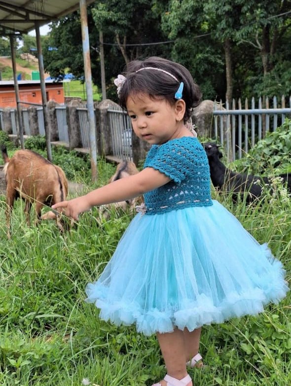 Our littlest model in a teal crochet dress top and tulle skirt